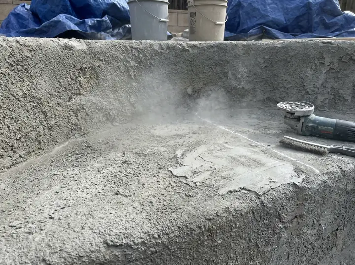 Pool surface preparation in progress, showing surface grinding and prep work before coating application.