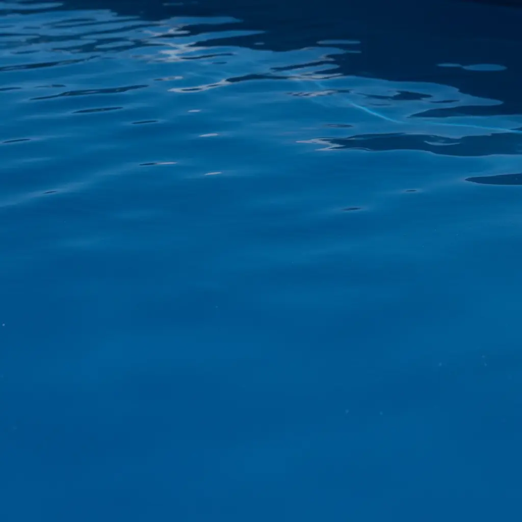 Close-up of smooth ecoFINISH polymer pool surface showing deep azure continuous coating with no staining, premium tactile finish in natural light